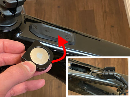An Apple AirTag holder attached under the TCU display on a Specialized ebike frame.